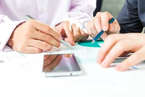 Collaborative discussion and analysis of documents during a business meeting in Stock Photos