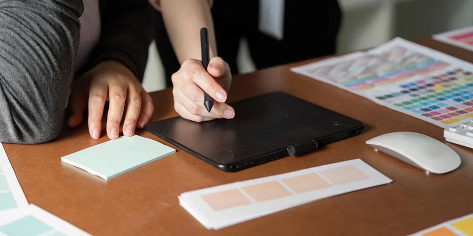 Collaborative graphic design process with digital tools and color swatches Stock Photos
