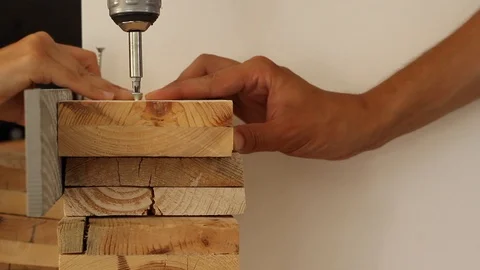 Collaborative Hands Screwing a Wooden Board Stock Footage 89774074