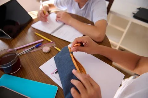 Collaborative homework session with focus on writing and drawing skills Stock Photos