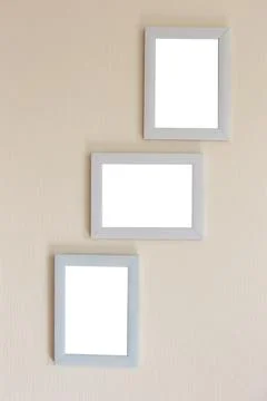 Collage of three white frames on a beige wall Stock-Fotos