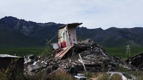 Collapsed building with faded murals surrounded by overgrown vegetation and Stock Footage 344322837