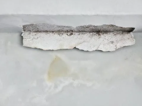 Collapsed plaster and peeling paint on a damaged white ceiling Photos