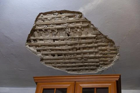Collapsed plaster from the white ceiling in the interior of an old house. Stock-Fotos