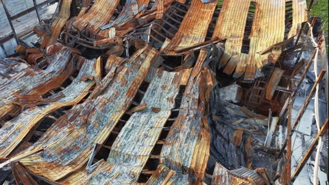 Collapsed roof structure of a building destroyed by fire, showing warped Stock Footage 341303883