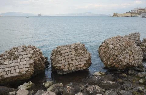 Collapsed wall into the sea Stock Photos