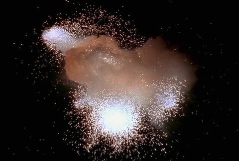 Collapsing explosion disgorging comets that shower sparks across the frame Stock Footage 86914877