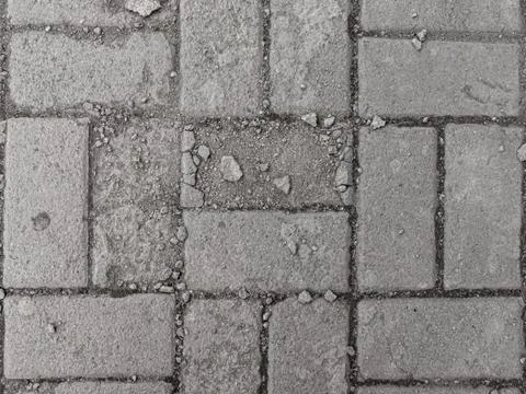 Collapsing low-quality gray paving slabs with a layered top layer Stock Photos