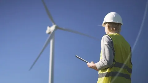 Collar worker standing near wind mill and using program on devic Video stock 111067286