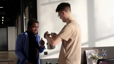 Colleague helps put on vr headset. Testing metaverse world, touching virtual Stock Footage 235392305