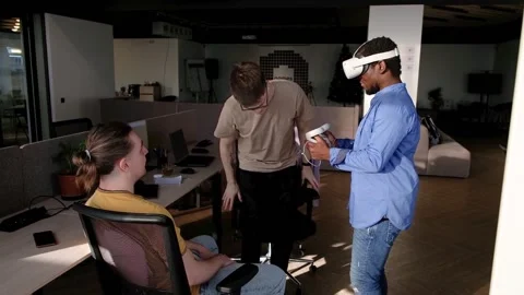 Colleague helps put on vr headset. Testing metaverse world, touching virtual Stock Footage 235855449