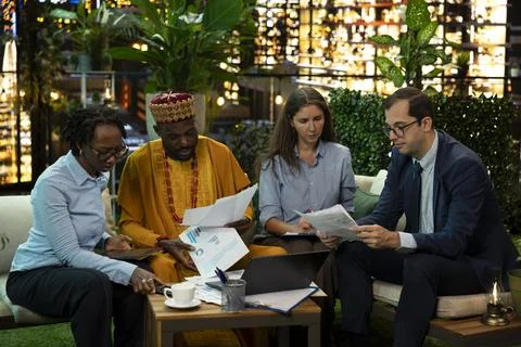 Colleagues analyze project documents in city workspace after hours Fotos de archivo