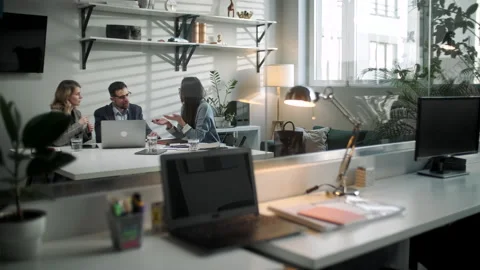 Colleagues And Clients Talking Strategy With Laptop And Tablet. In Creative Видео 130944944