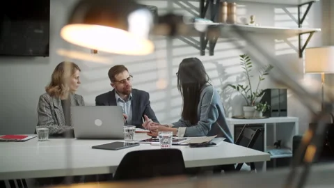 Colleagues And Clients Talking Strategy With Laptop And Tablet. In Creative Видео 130950184