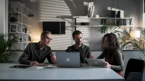 Colleagues And Clients Talking Strategy With Laptop And Tablet. In Creative Stock Footage 132815744