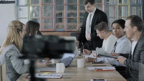 Colleagues are sitting at a large table and preparing to discuss the project Stock Footage 124550410