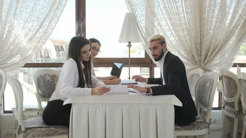 Colleagues are sitting at a table in a restaurant, talking Video stock 130912400