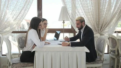 Colleagues are sitting at a table in a restaurant, talking Stock Footage 130912951