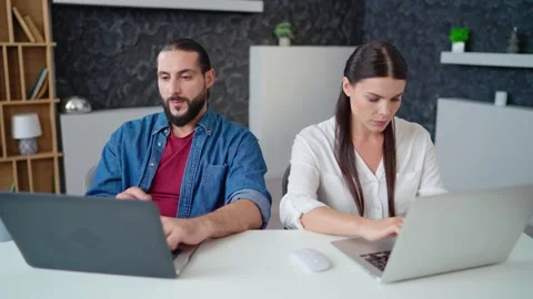 Colleagues are working concentratedly at the same table using modern laptops Stock Footage 236588300