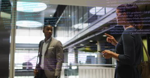 Colleagues in businesswear analyzing code on display in atrium, smartphone, Foto stock