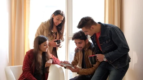 Colleagues busy working on a portable internet communication device when suddenl Stock Footage 101164279