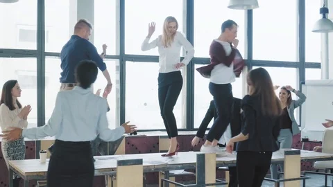 Colleagues celebrate the end of the work week, have fun dancing on the table Stock Footage 108372296