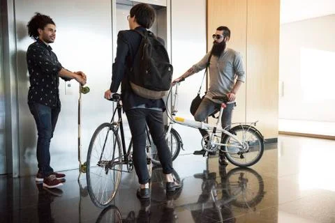 Colleagues chatting while waiting for elevator Fotos de archivo