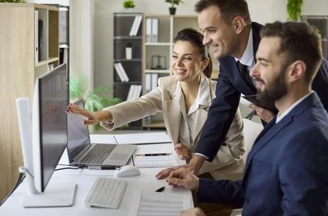 Colleagues collaborating at computer in bright office, data review and planning Fotos de archivo