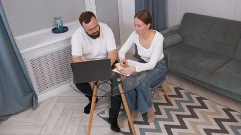 Colleagues collaborating on laptop: analyzing documents at shared workspace Vidéo 317442788