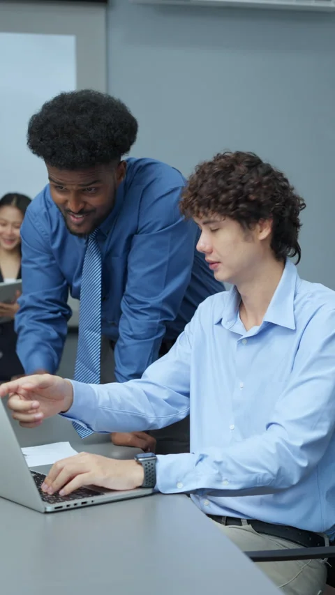 Colleagues Collaborating on Laptop in Office Stock Footage 285720142