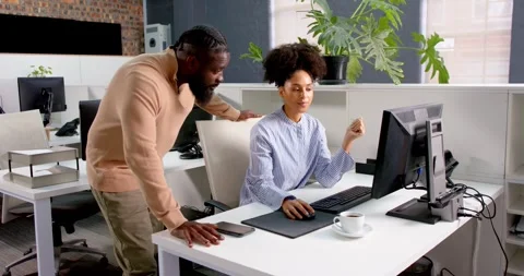 Colleagues collaborating at office desk, discussing project on computer screen Stock Footage 346144100