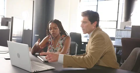Colleagues collaborating at office desk, using computer for project discussion Stock Footage 345804866