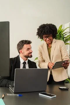 Colleagues collaborating in an office, sharing ideas and using a tablet for Stock Photos