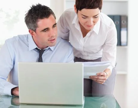 Colleagues comparing a blueprint folder to an electronic one Foto stock