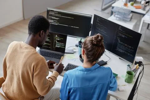 Colleagues developing security codes in team 库存照片