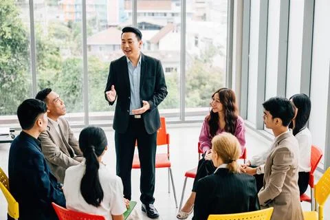 Colleagues from different backgrounds work and discuss in a modern office. They Stock Photos