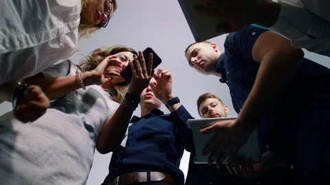 Colleagues discuss the problem using gadgets mobile phones and tablets, standing Stockbeeldmateriaal 103939785