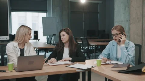 Colleagues discuss projects in office setting while using laptops Stock-Footage 326325055