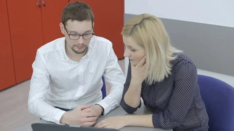 Colleagues discuss something important in the office, the man and the woman at Stock Footage 98130296