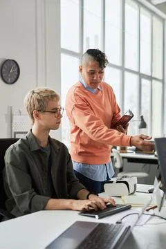 Colleagues discussing online presentation on computer Foto stock