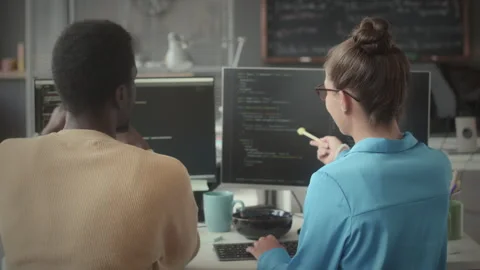 Colleagues Discussing Programming Code on Computer Monitor Stock Footage 263701164