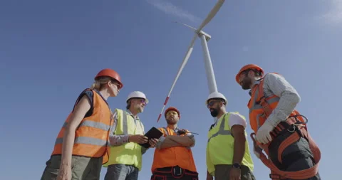 Colleagues discussing windmill on wind farm Stock Footage 140291541