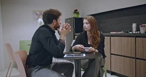 Colleagues discussing work in a modern office break room while having coffee. Stock Footage 277298440