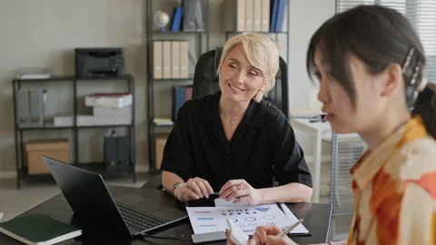 Colleagues Discussing Working Tasks at Table with Papers in Modern Office Stock Footage 335752111