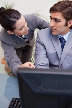 Colleagues in discussion while using computer at office Foto stock