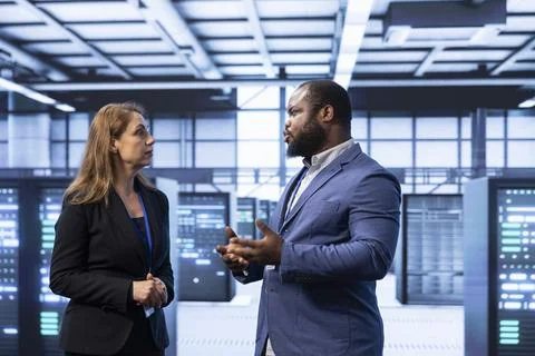 Colleagues doing brainstorming in server hub after installing storage units Stock Photos