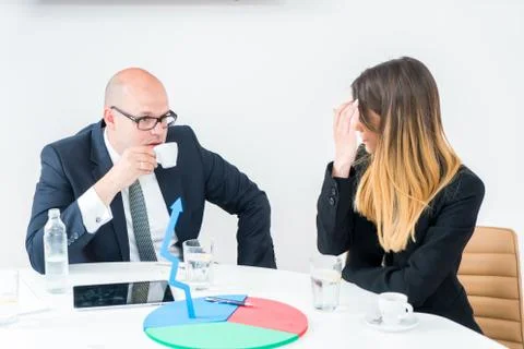 Colleagues drinking coffee in office while discussing new project Stock Photos