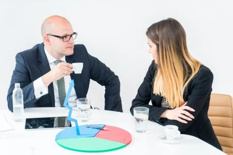 Colleagues drinking coffee in office while discussing new project Stock Photos