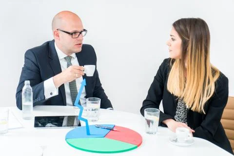 Colleagues drinking coffee in office while discussing new project Stock Photos