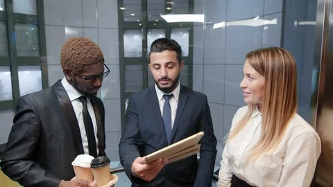 Colleagues in elevator with tablet computer Vidéo 100904579